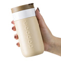 Dopper Travel Mug Small 300ml Earthy Brown (Beige) vastgehouden in hand van vrouw