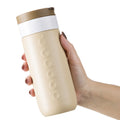 Dopper Travel Mug Large 400ml Earthy Brown (beige) - in hand van vrouw vastgehouden