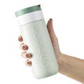 Dopper Travel Mug Large 400ml Forest Green (groen) - in hand van vrouw vastgehouden