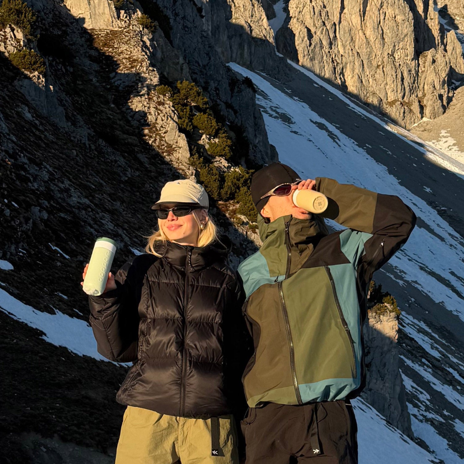 Man en vrouw met bergwand op achtergrond drinken uit travel mug large forest green en earthy brown