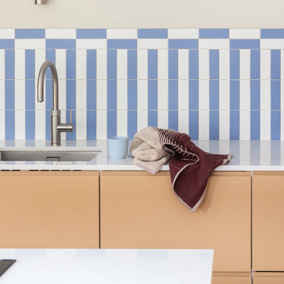 TweeDoek in diep rood, liggend op het keukenblok naast de spoelbak
