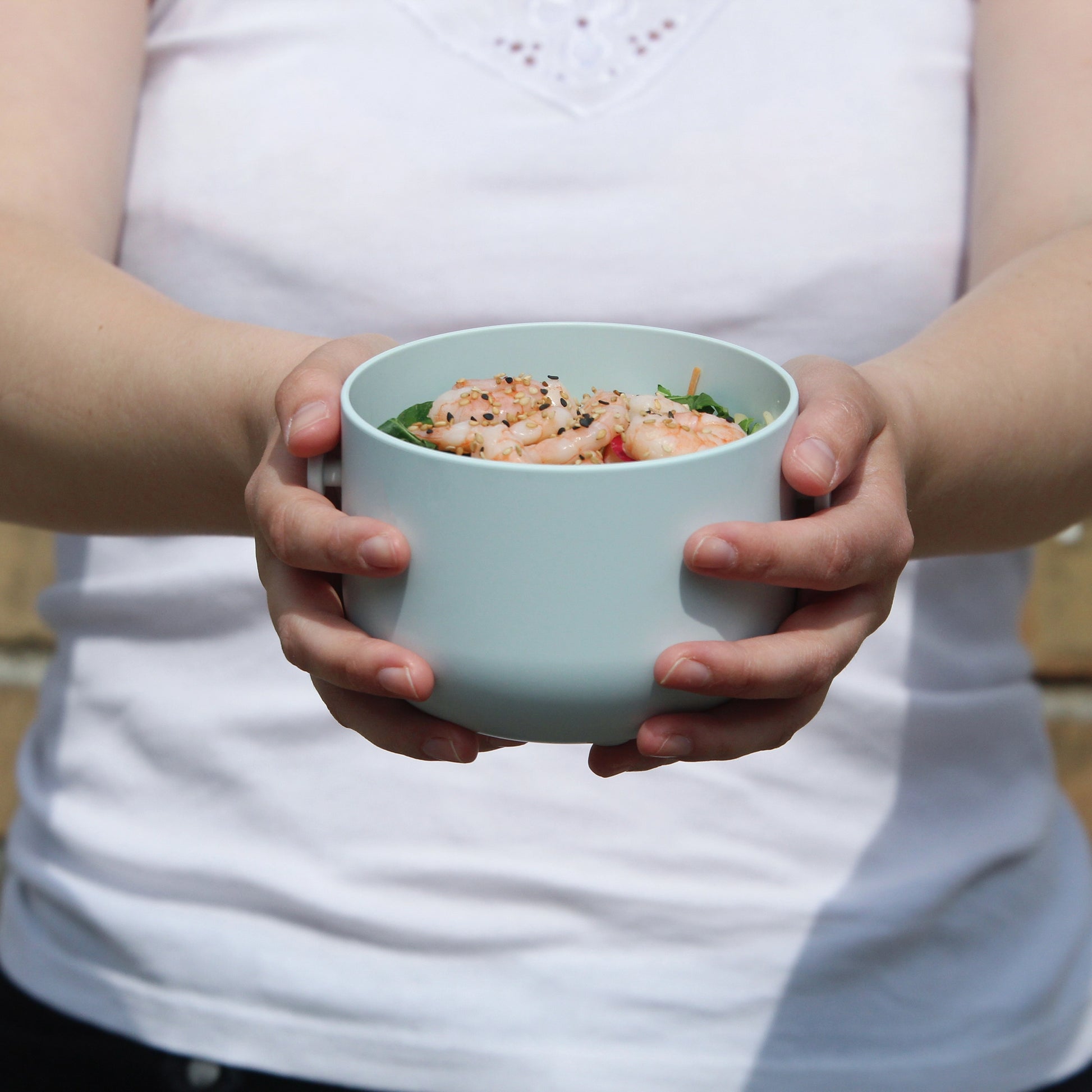 Uhmm Bowl 02 Small lichtblauw in hand met garnalensalade.