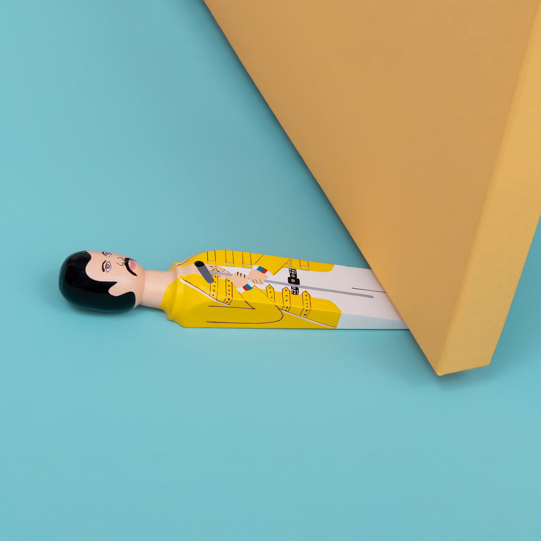 Wedgie Deurstopper Freddy (Freddie Mercury) - vooraanzicht met witte achtergrond en kleine ronde afbeelding onder deur rechtsboven