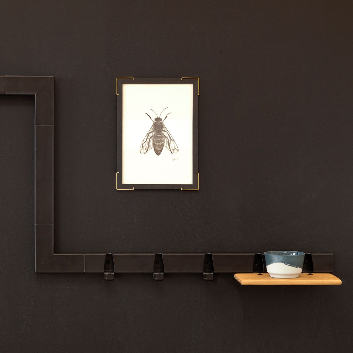 Coatrack by the Meter Zwart van Vij5 - met hoekstukken en 20cm zonder haakjes in verschillende hoogte aangebracht op zwarte wand