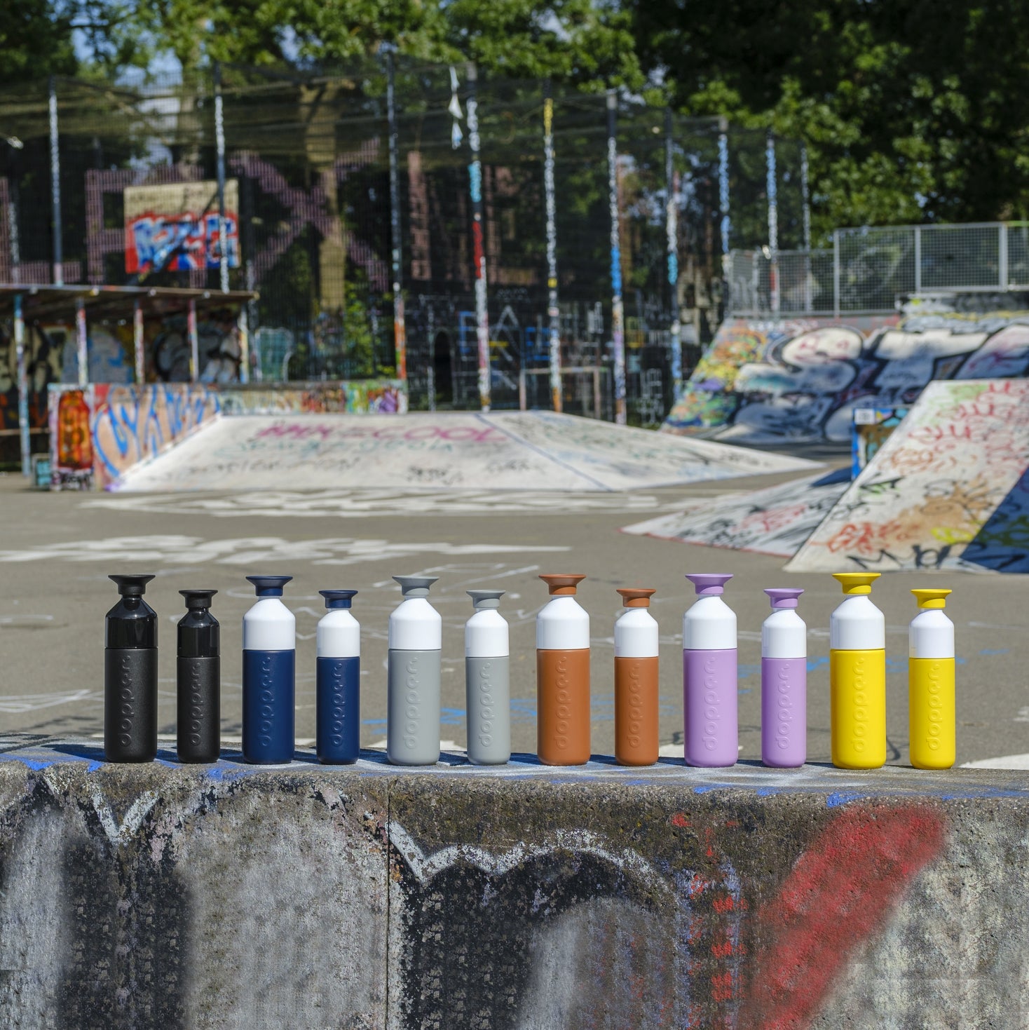 Dopper Insulated Small Lemon Crush│Thermosfles 350ml Geel│art. 4466│grope grote en kleine maat in rij met skatebaan op achtergrond