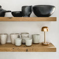 Humble Two Oplaadbare tafellamp Gold│HUMTL00201│Draadloos│op houten plank naast serviesgoed