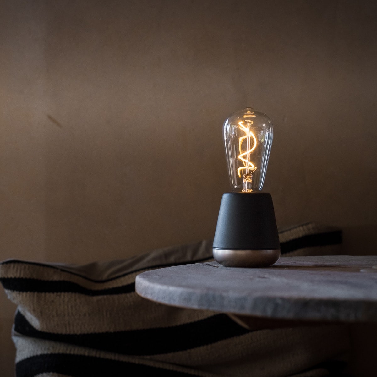 Humble One Smart Oplaadbare Tafellamp Donkergrijs│art. HUMTLS0101│Slimme Verlichting│op rond tafeltje met licht aan