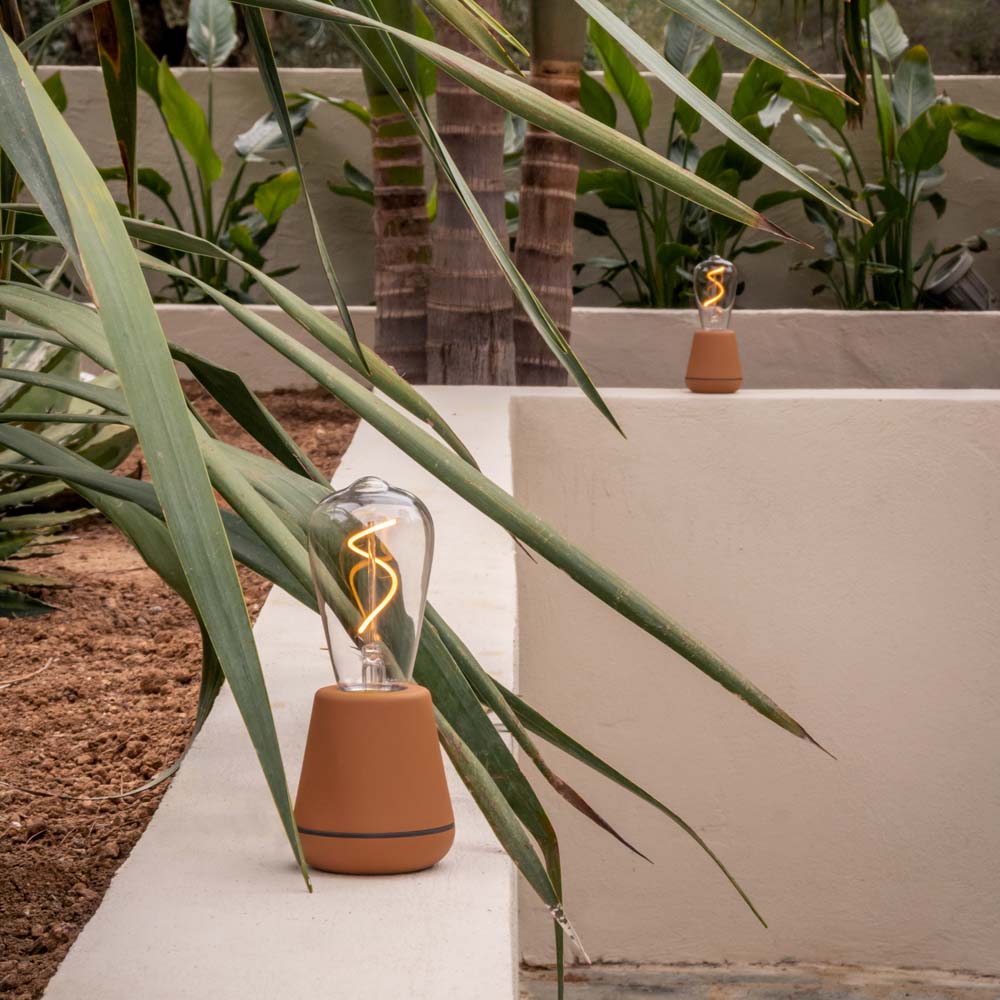 Humble One Outdoor Oplaadbare Tafellamp Cinnamon│Buitenverlichting│art. HYMTL00118│in tuin met licht aan tussen planten