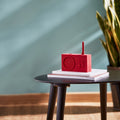 Lexon Tykho-3 FM Radio en Bluetooth-speaker│Donkerrood│oplaadbaar│art. LA119DR│op bijzettafel met boeken