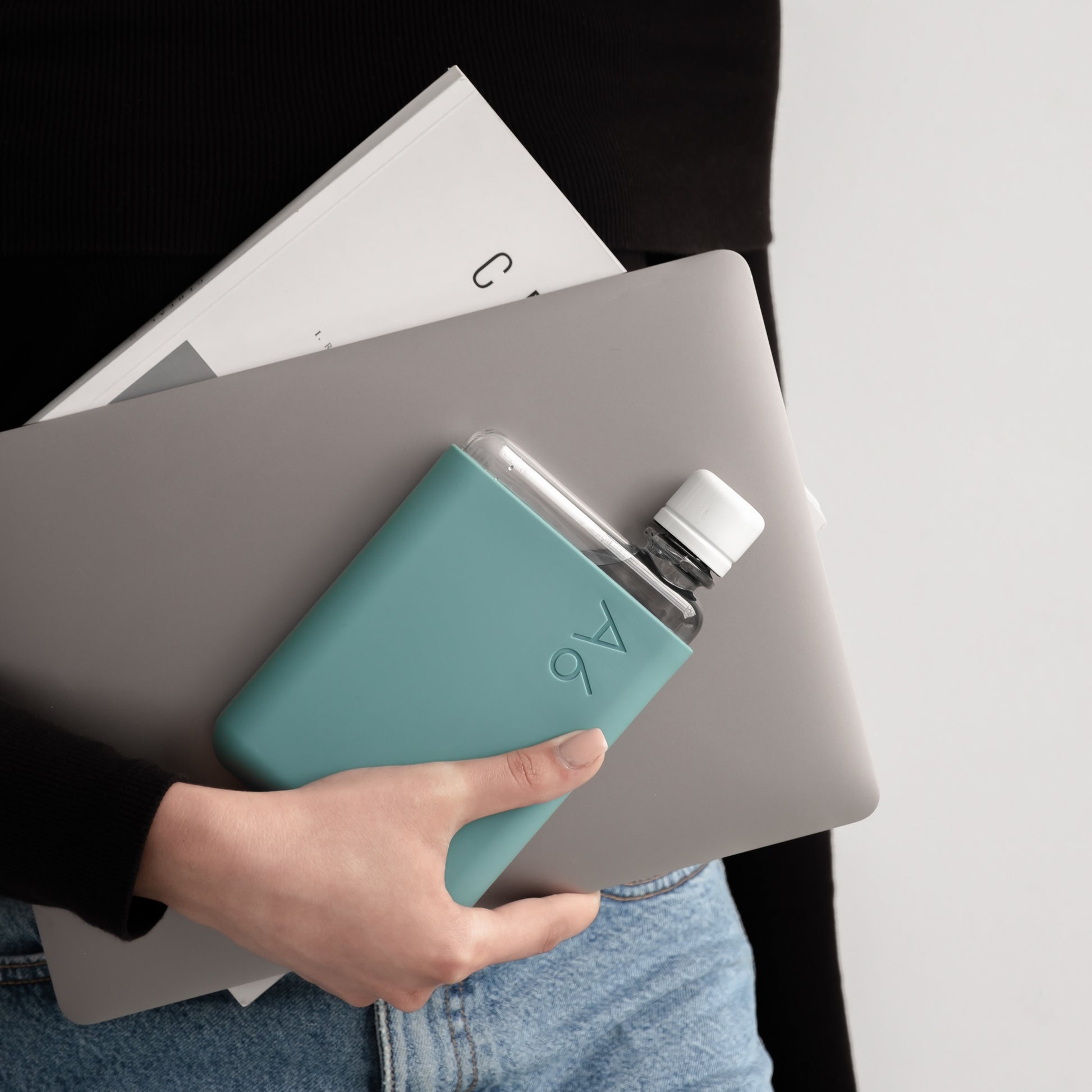 Memobottle Silicone Sleeve A6│Sea Mist│Drinkfles│lifestyle foto met laptop en Memobottle in hand
