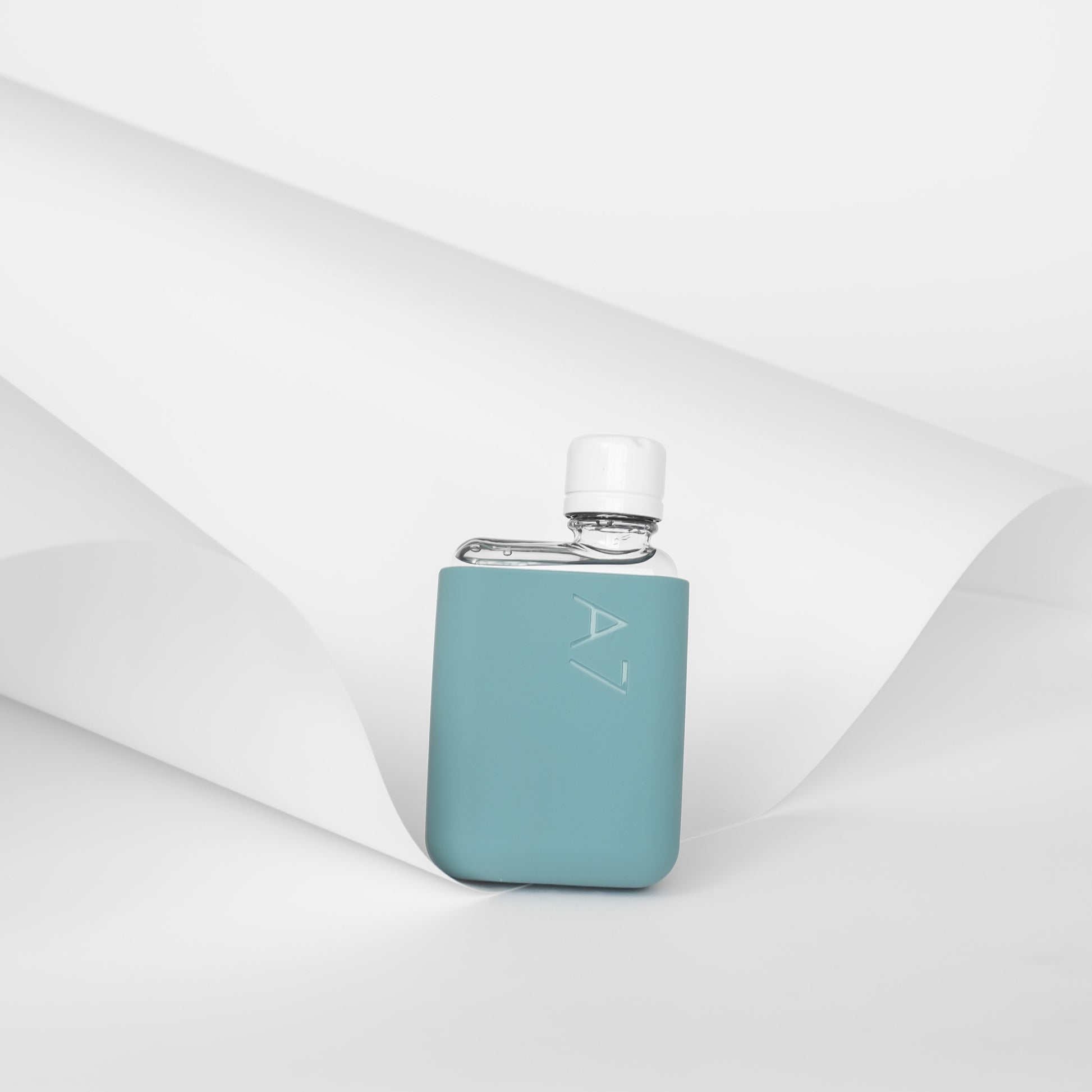 Memobottle Silicone Sleeve A7│Sea Mist│Drinkfles│foto met gevulde fles en achtergrond papier