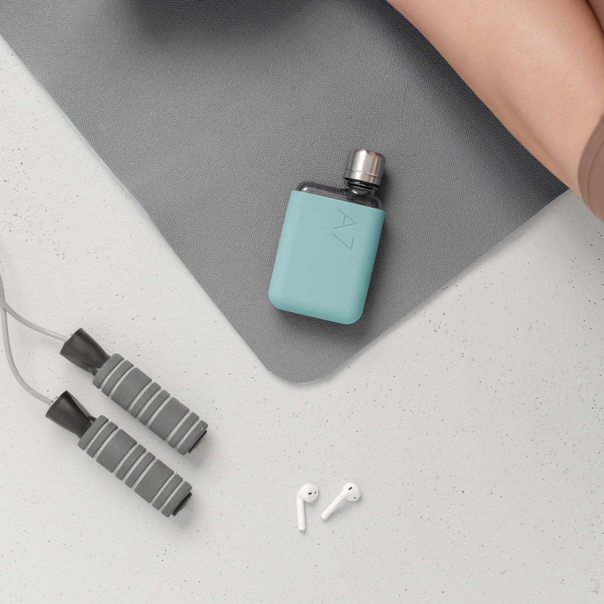 Memobottle Silicone Sleeve A7│Sea Mist│Drinkfles│lifestyle foto op bureau met oordopjes