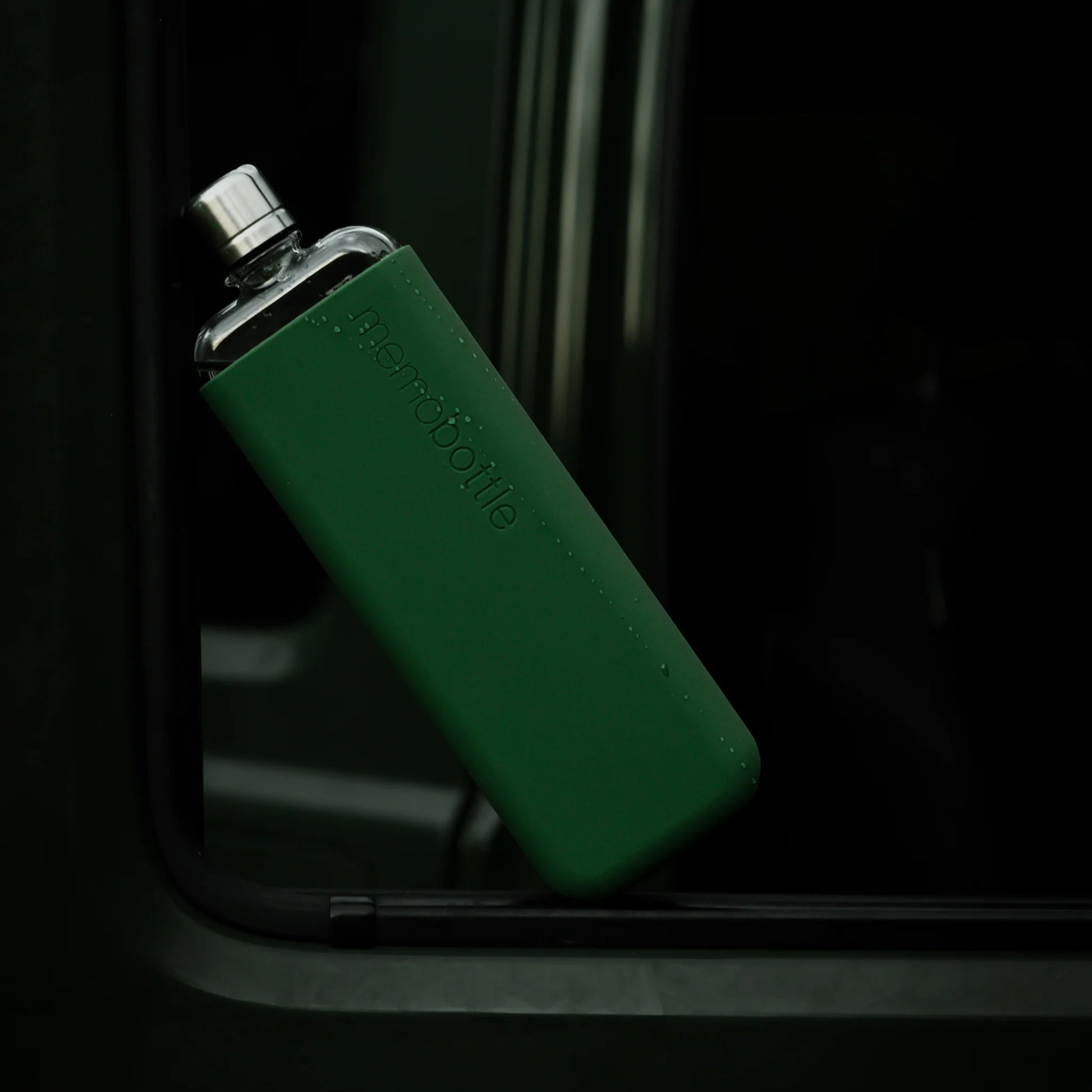 Memobottle Silicone Sleeve Slim Moss Green│Drinkfles│foto met Memobottle in raamopening groene auto