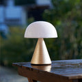 Lexon Mina Large Oplaadbare Tafellamp Goud│art. LH65MD│op buitentafel met regendruppels