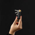 Key Organizer Orbitkey│Saffiano Liquorice Black│SFLO-2-LBBKYG│sleutelhanger leer in hand donkere achtergrond