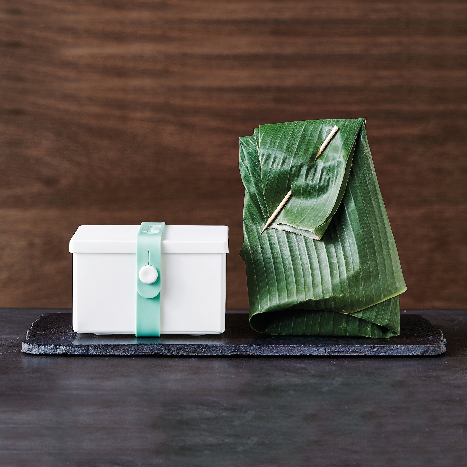 Uhmm 02 Opvouwbare Luchbox Wit│Art. 982409│met strap Morning Mist naast zakje van bladeren